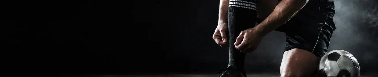 Fotbollsspelare i mörka fotbollskläder på träningsplan