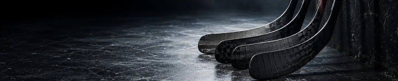 Hockeyklubbor och puck på mörk isyta